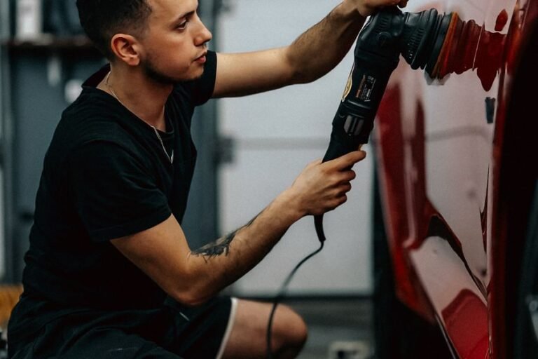 Detailer machine polishing a red car